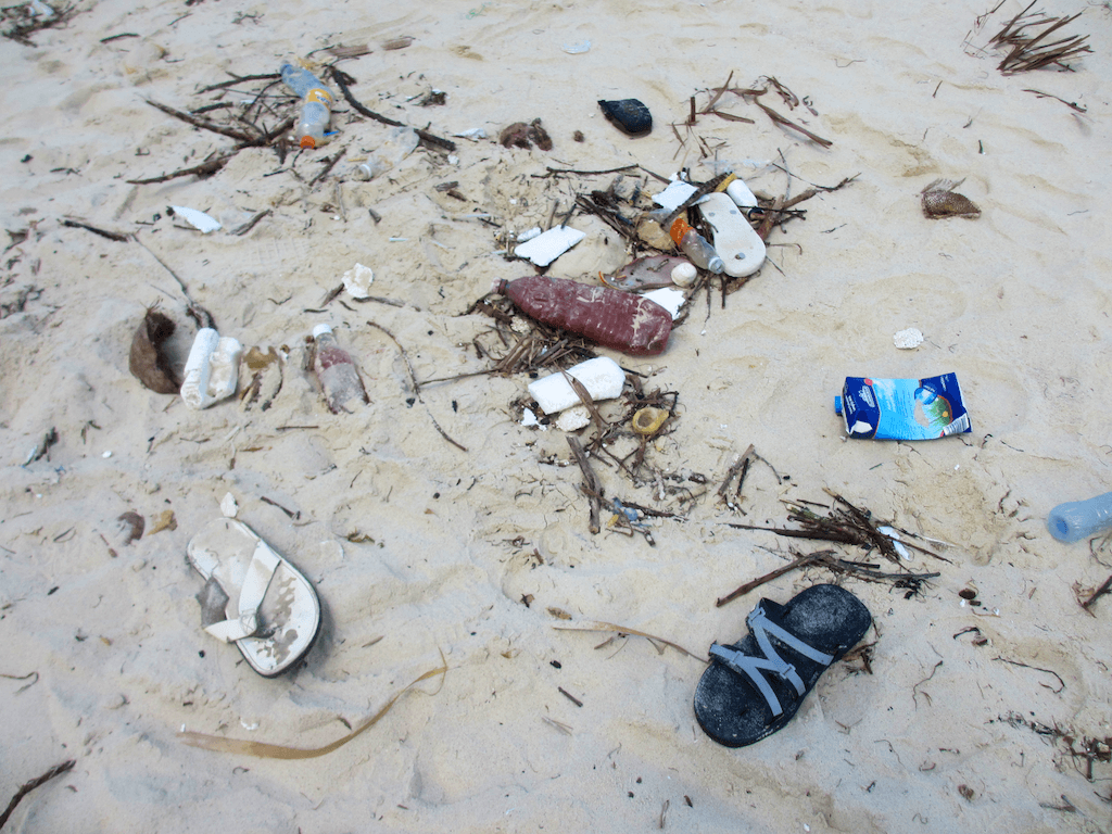 Flip Flops am Strand Müll auf einem Sandstrand
