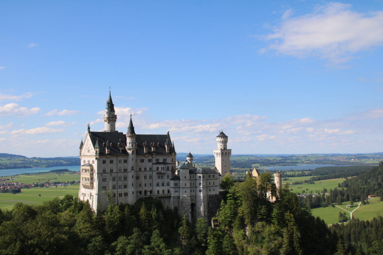 Das weltberühmte Schloss Neuschwanstein Das Schloss Neuschwanstein mit Seen und Wiesn im Hintergrund